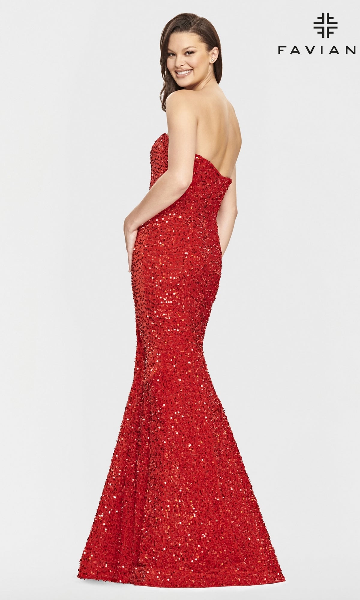 A woman smiles sideways in a Faviana Strapless Sweetheart Long Sequin Prom Gown, its red mermaid silhouette shimmering against a white background, with the Faviana name and logo shown in the top right corner.